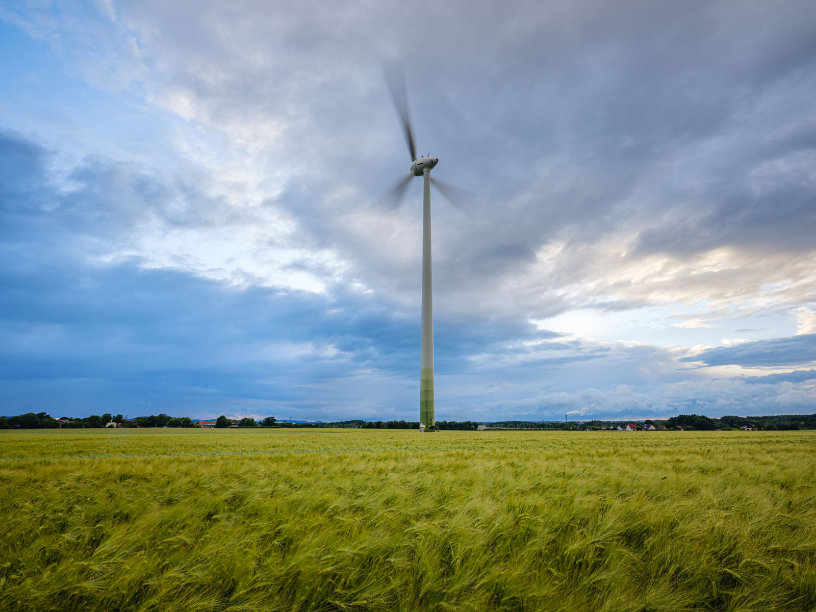 Wind turbine and cloudy sky near 'Brönninghausen' on an evening in June 2020 (Bielefeld, Germany).