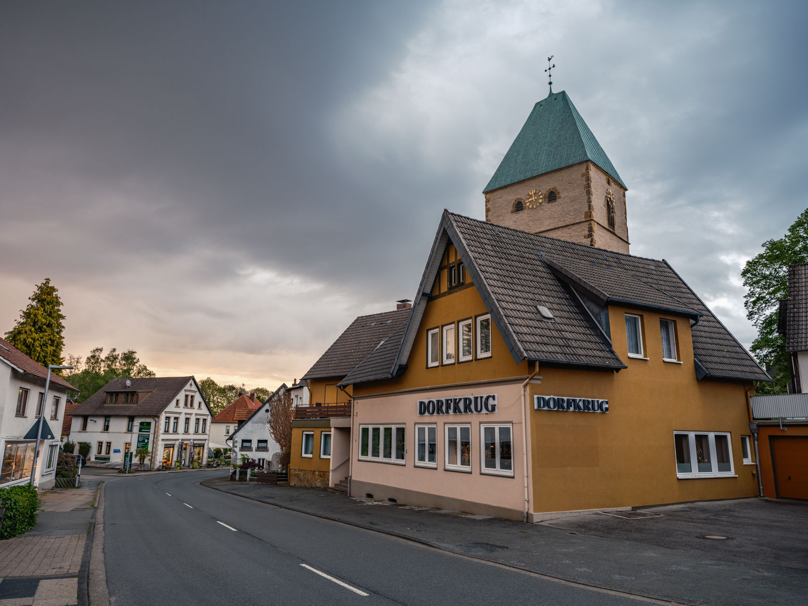 Village road, tavern and church in May 2021 (Bielefeld-Kirchdornberg, Germany).