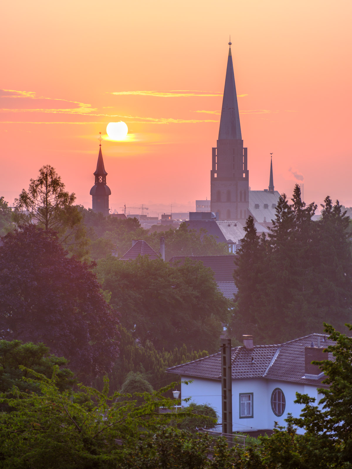 Tower of Nikolai church and Bielefeld city center at sunrise in July 2021 (Bielefeld, Germany).
